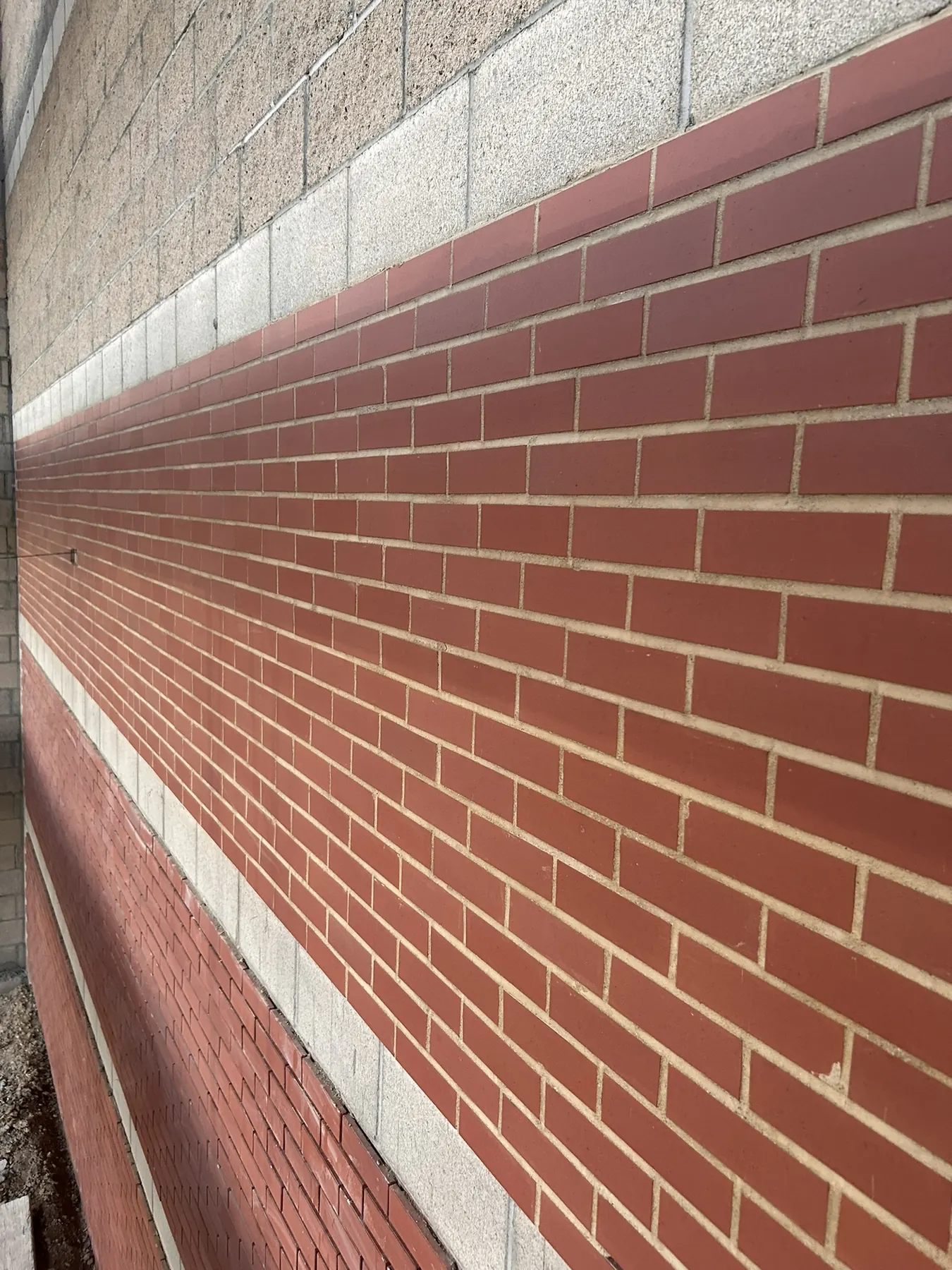 Close-up of red brick coursing with contrasting light banding on a commercial building