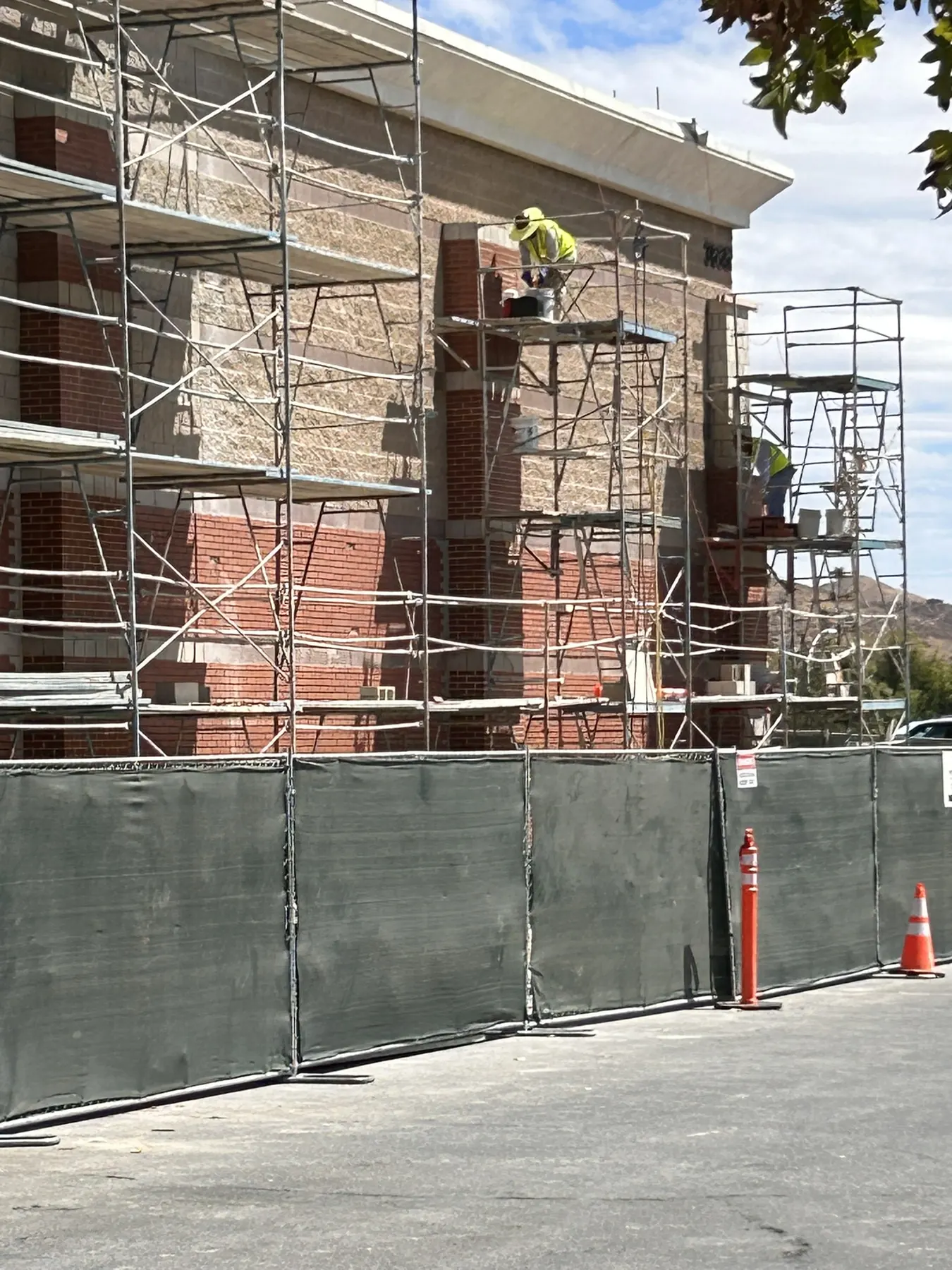 Brick veneer pilasters and banding under construction on a commercial building, viewed from the street