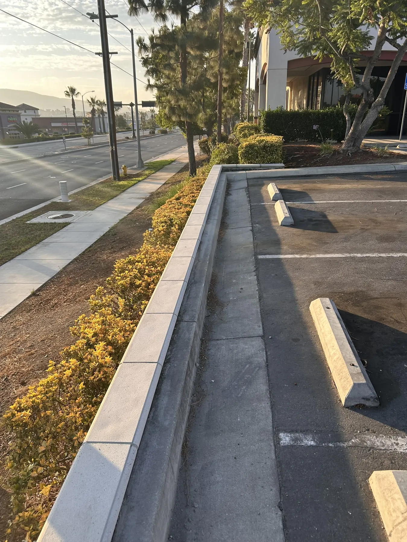 Precast cap wall with coping along a retail center sidewalk and parking area