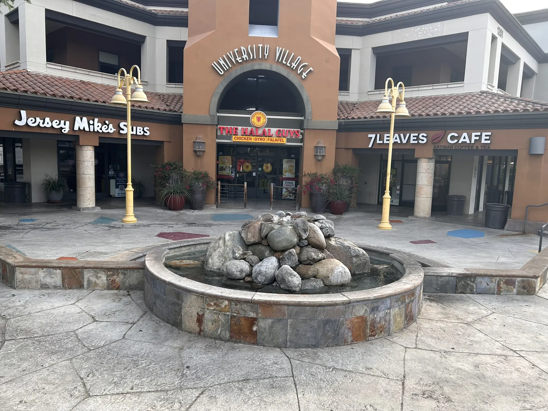 Finished stacked river-stone fountain with a tile base at a Southern California retail plaza