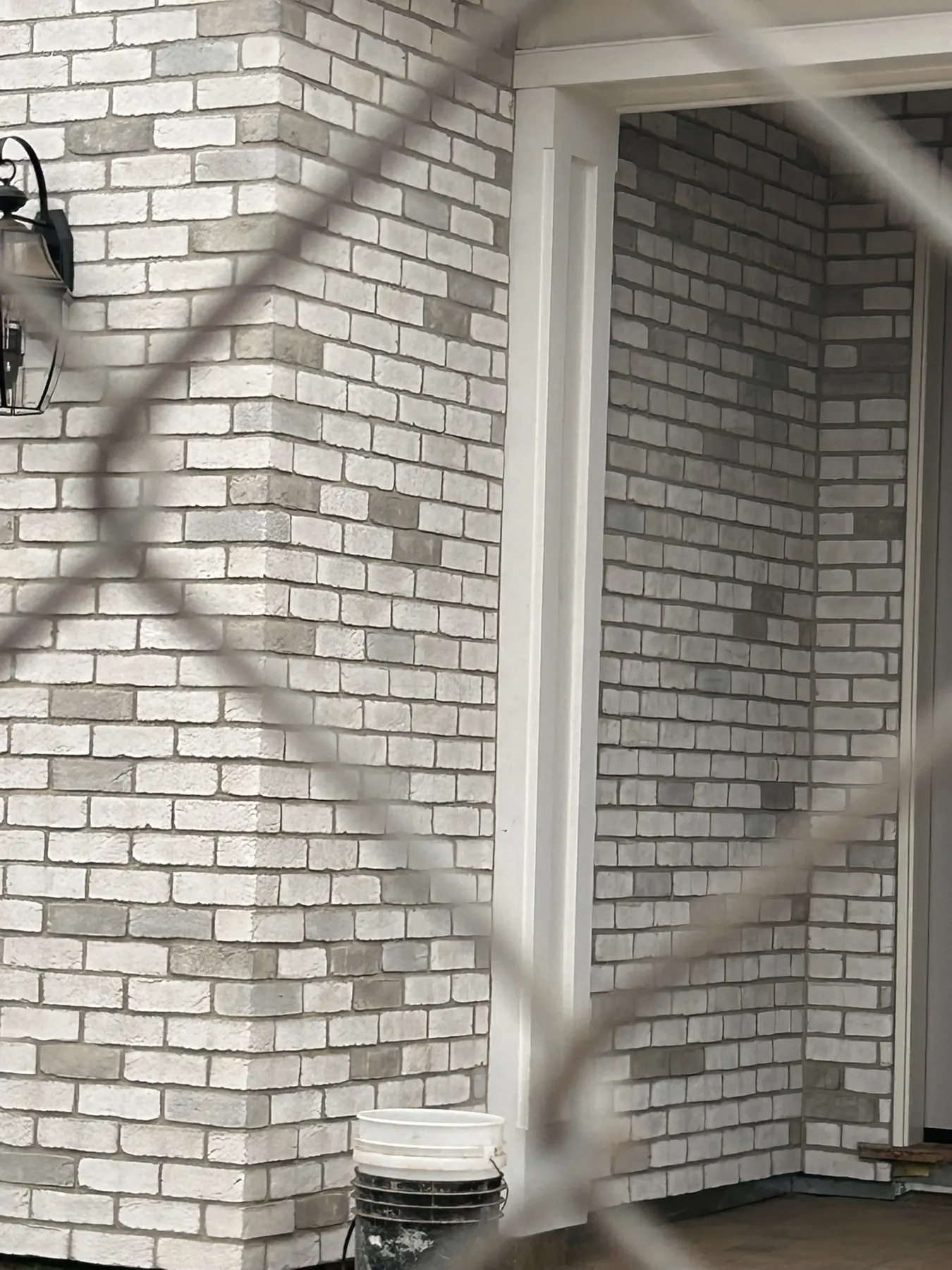 Close-up of finished gray and white brick veneer at a home's entry corner