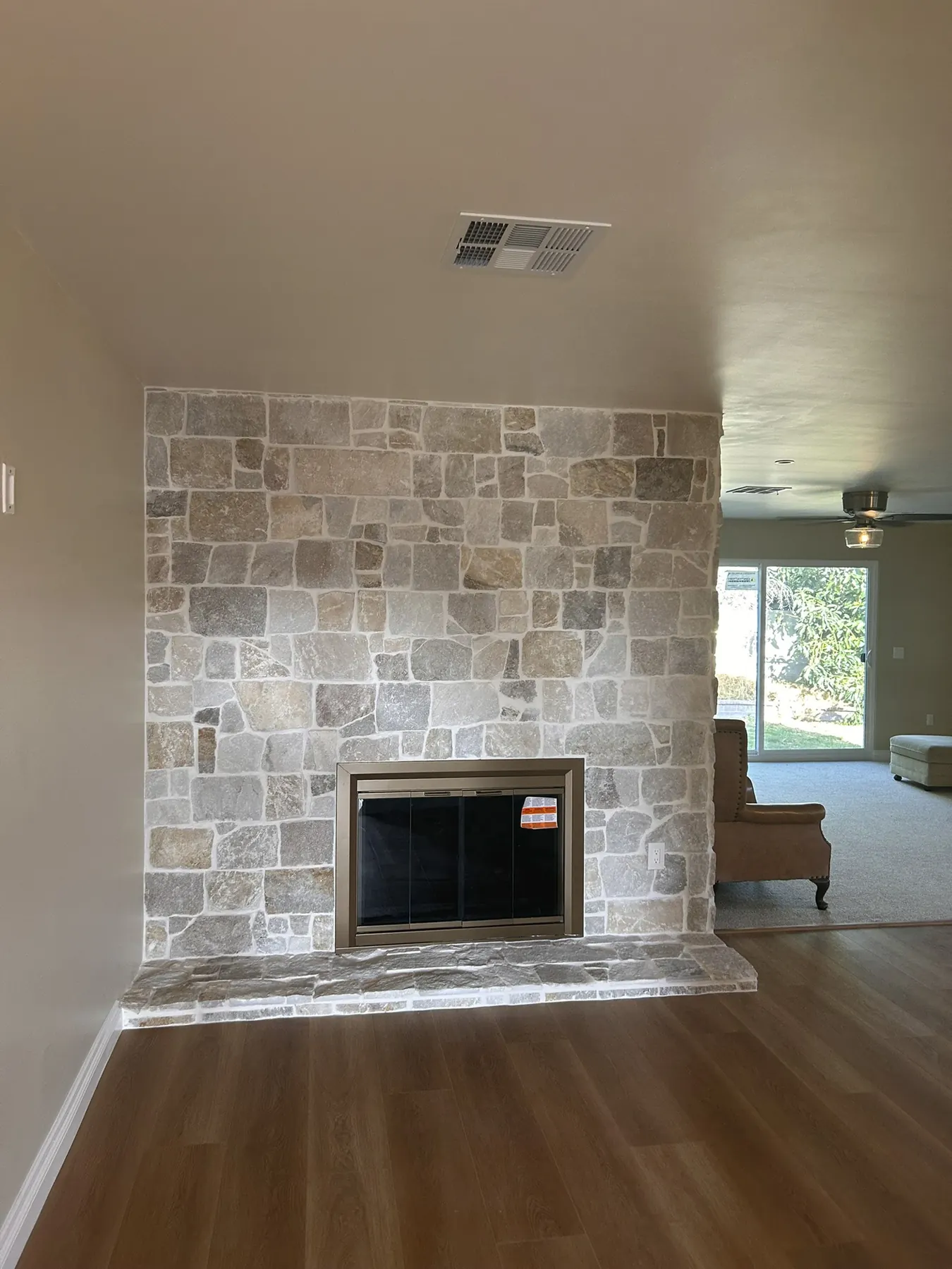 Finished floor-to-ceiling natural stone fireplace surround in a Southern California living room