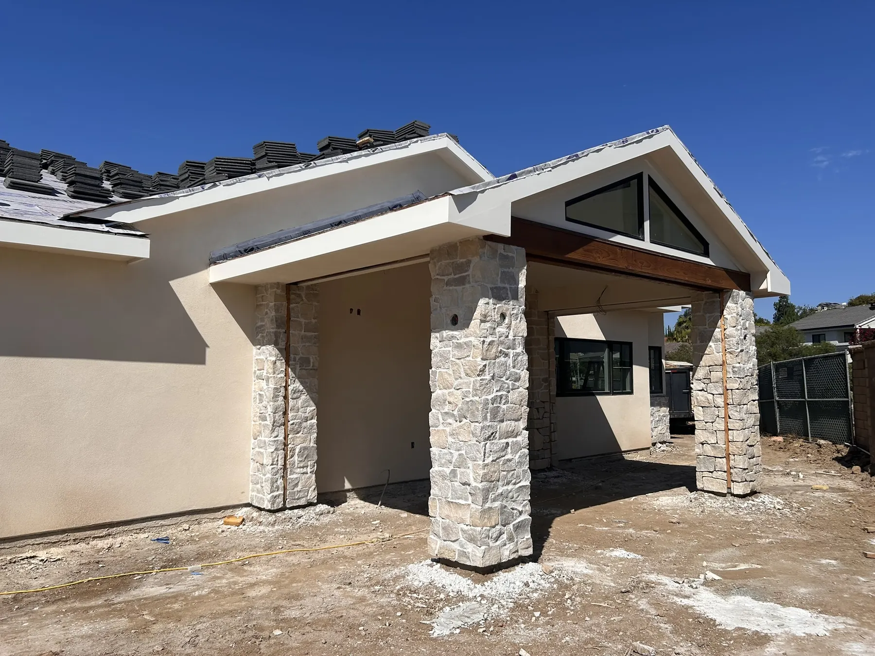 Natural stone veneer columns supporting a covered entry on a modern Southern California home