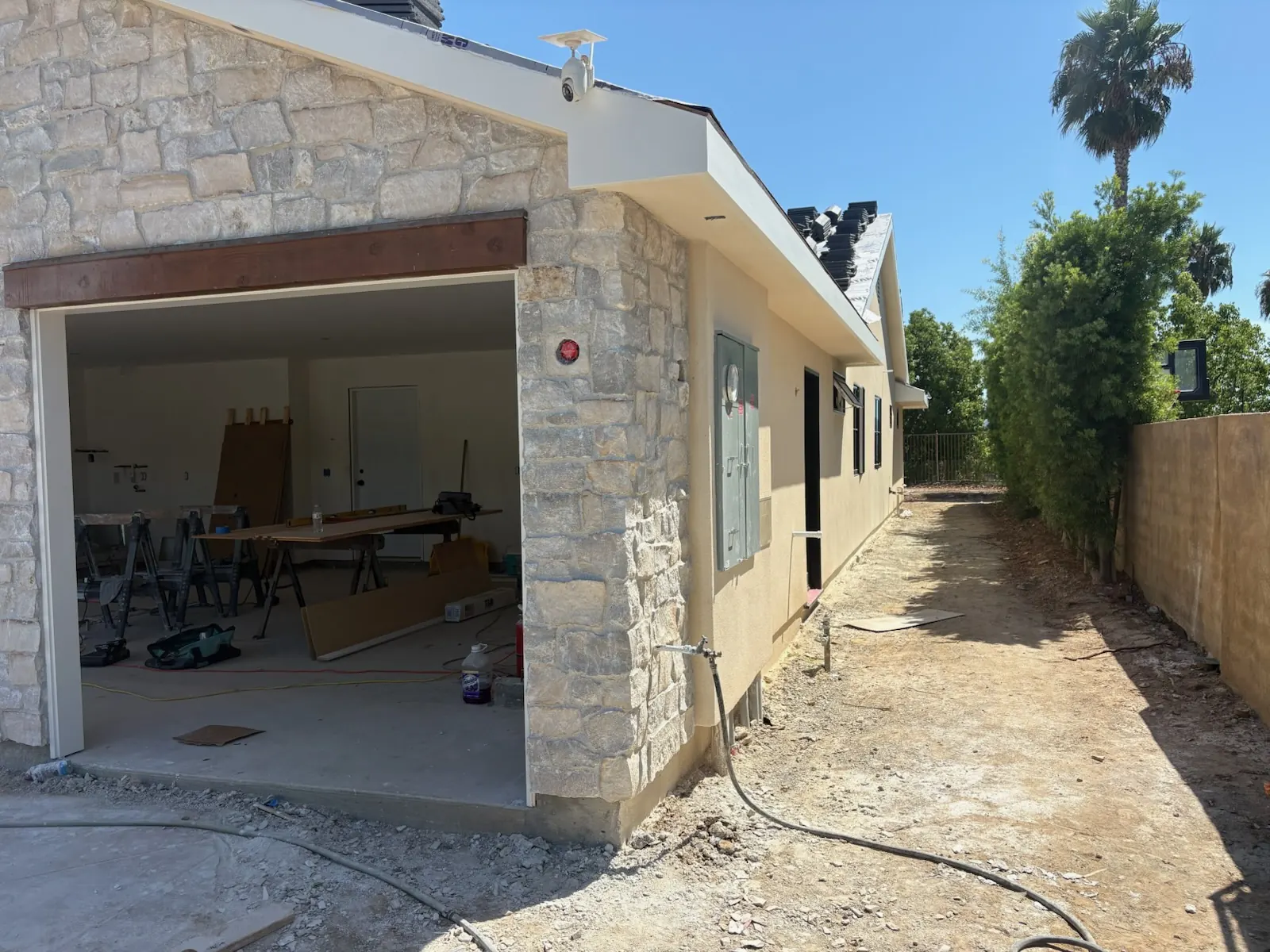 Finished natural stone veneer covering a home's garage exterior and side wall